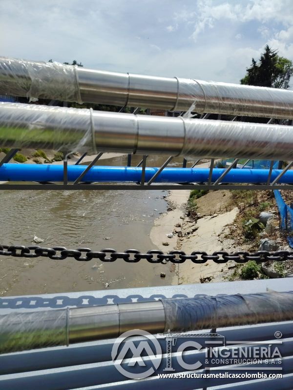 Examine empalmes metálicos que conectan pasamanos pulidos con continuidad sobre el cauce urbano abierto en Bogotá, Colombia. Montajes, Ingeniería y Construcción. MIC SAS.