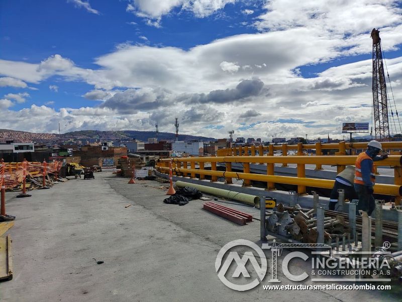Siga la instalación de barandas, con herramientas, soportes y perfiles ordenados junto al frente activo en Bogotá, Colombia. Montajes, Ingeniería y Construcción. MIC SAS.