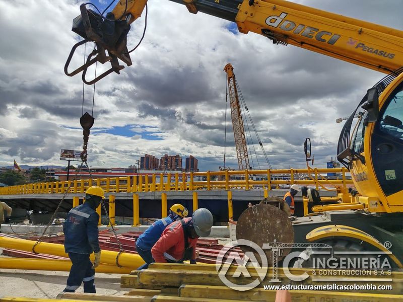 Oriente los perfiles agrupados bajo el brazo telescópico mediante eslingas controladas por la cuadrilla en Bogotá, Colombia. Montajes, Ingeniería y Construcción. MIC SAS.