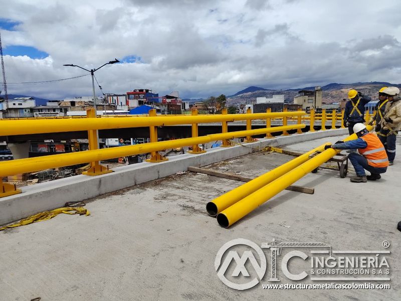 Acompañe el posicionamiento manual de tubos amarillos junto al pasamanos ya instalado durante esta fase en Bogotá, Colombia. Montajes, Ingeniería y Construcción. MIC SAS.