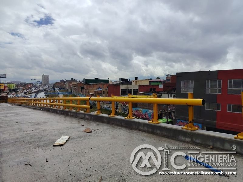 Visualice la baranda tubular amarilla que protege de manera continua el corredor elevado con seguridad, en Bogotá, Colombia. Montajes, Ingeniería y Construcción. MIC SAS.