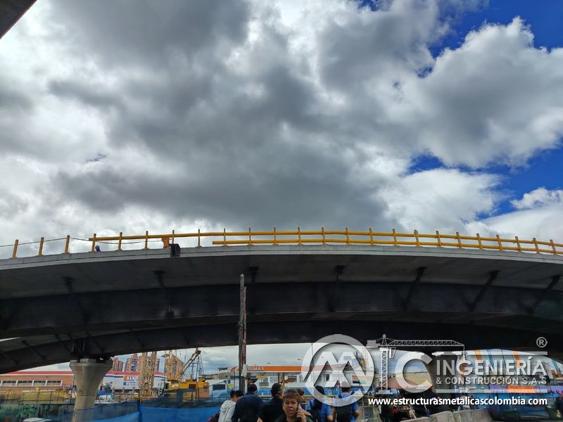 Contemple desde nivel inferior la baranda amarilla continua que acompaña la curva superior del viaducto en Bogotá, Colombia. Montajes, Ingeniería y Construcción. MIC SAS.