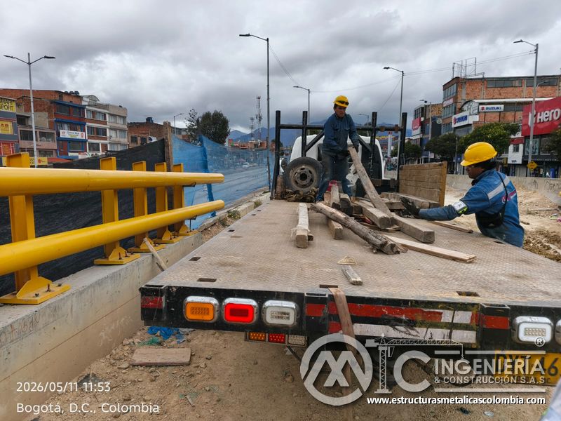 Observe el retiro de maderos y apoyos auxiliares desde el camión junto a barandas instaladas del puente en Bogotá, Colombia. Montajes, Ingeniería y Construcción. MIC SAS.
