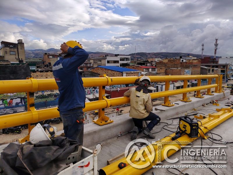 Conozca la soldadura del travesaño bajo que fija la baranda amarilla y refuerza la protección del borde en Bogotá, Colombia. Montajes, Ingeniería y Construcción. MIC SAS.