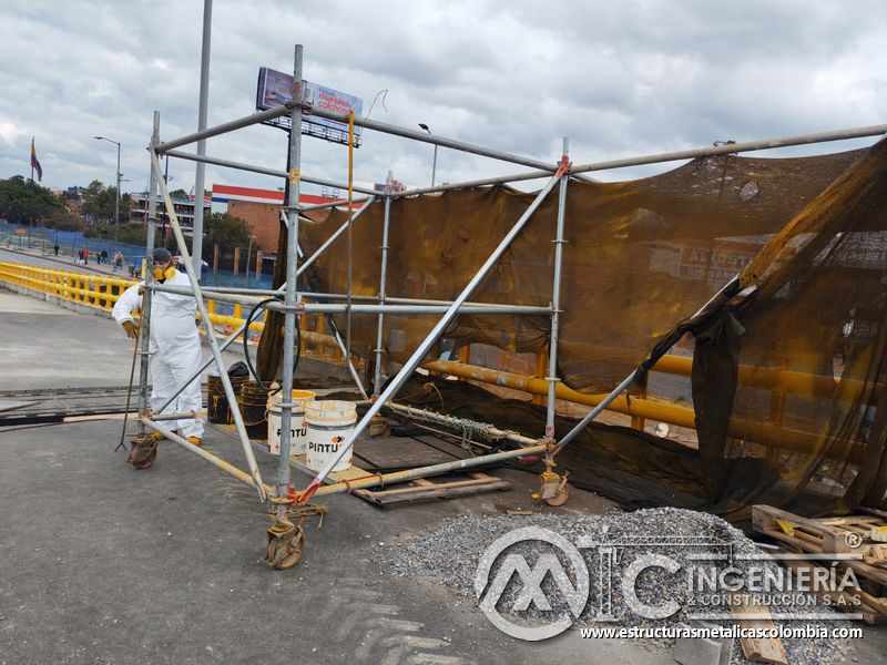 Observe el aislamiento móvil usado para pintar la baranda amarilla del puente con ejecución responsable en Bogotá, Colombia. Montajes, Ingeniería y Construcción. MIC SAS.