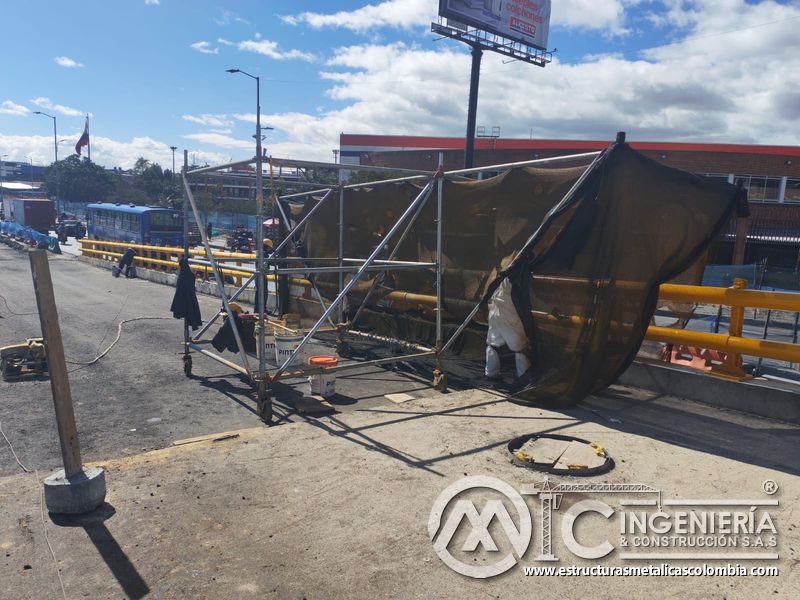Descubra la cabina móvil con malla que controla partículas durante el rociado para infraestructura vial en Bogotá, Colombia. Montajes, Ingeniería y Construcción. MIC SAS.