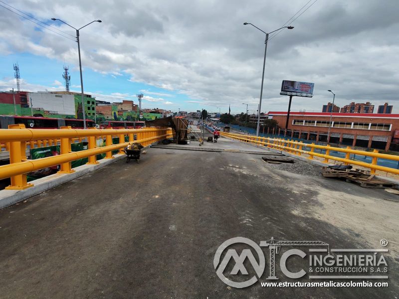 Contemple el puente con barandas amarillas, alumbrado vial y zona de intervención con precisión técnica en Bogotá, Colombia. Montajes, Ingeniería y Construcción. MIC SAS.