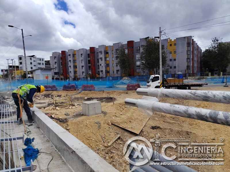 Observe la perforación del muro mientras los pasamanos aguardan su montaje durante la intervención vial en Bogotá, Colombia. Montajes, Ingeniería y Construcción. MIC SAS.