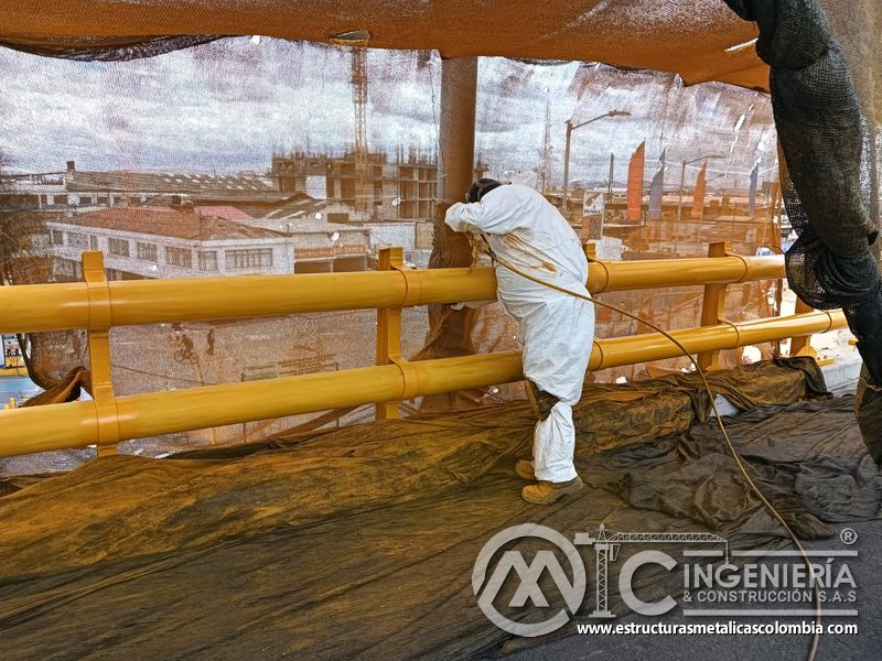 Conozca la pintura por aspersión aplicada dentro de un área completamente aislada sobre el tablero vial en Bogotá, Colombia. Montajes, Ingeniería y Construcción. MIC SAS.