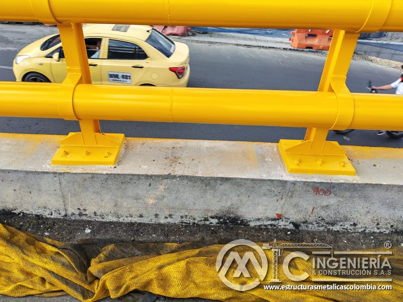 Examine las placas atornilladas que soportan la defensa tubular amarilla mediante práctica responsable, en Bogotá, Colombia. Montajes, Ingeniería y Construcción. MIC SAS.