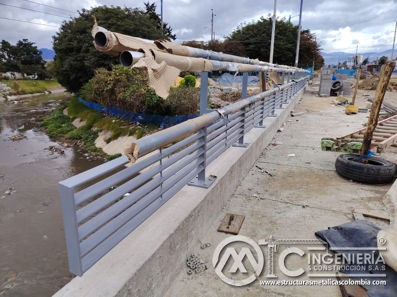 Contemple la baranda gris junto al canal con pasamanos protegidos para el montaje bajo revisión experta en Bogotá, Colombia. Montajes, Ingeniería y Construcción. MIC SAS.