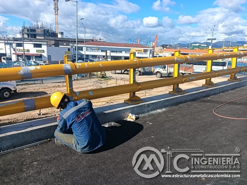 Aprecie el retoque de recubrimiento en juntas y apoyos de la defensa metálica para infraestructura vial en Bogotá, Colombia. Montajes, Ingeniería y Construcción. MIC SAS.