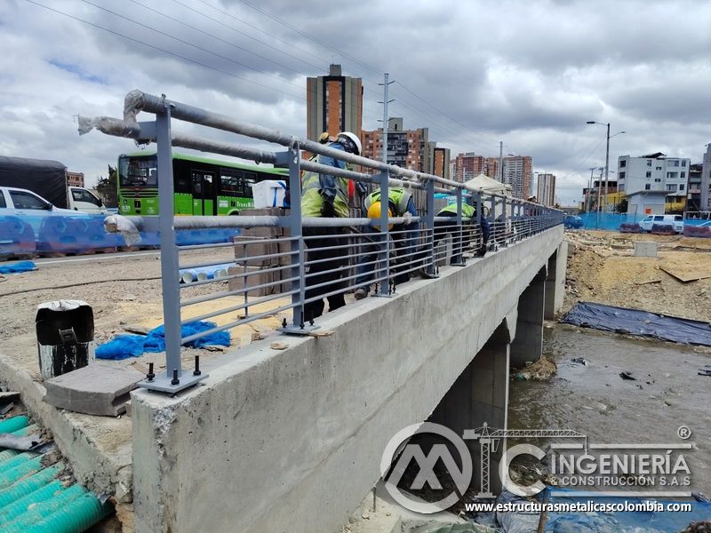 Contemple la cuadrilla que instala la baranda mientras circula un bus urbano con calidad y buen control en Bogotá, Colombia. Montajes, Ingeniería y Construcción. MIC SAS.
