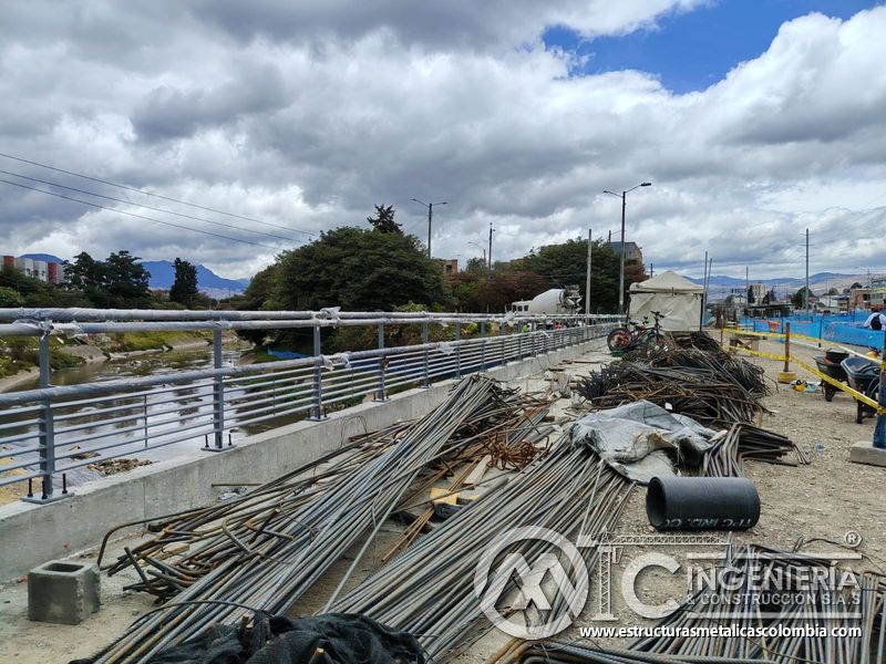 Contemple los paquetes de varilla organizados junto a la baranda del canal durante la intervención vial en Bogotá, Colombia. Montajes, Ingeniería y Construcción. MIC SAS.