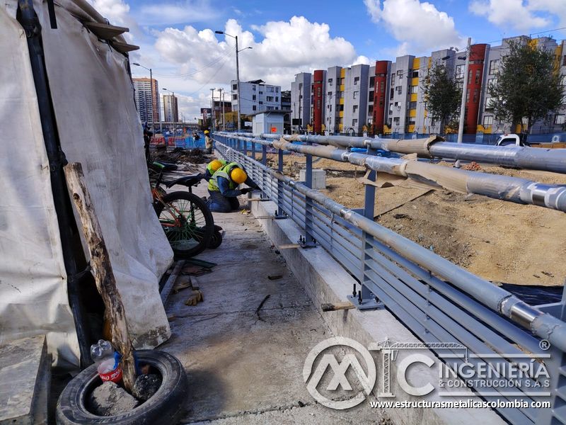 Contemple el cerramiento gris que se extiende junto al cauce y el campamento bajo gestión especializada en Bogotá, Colombia. Montajes, Ingeniería y Construcción. MIC SAS.