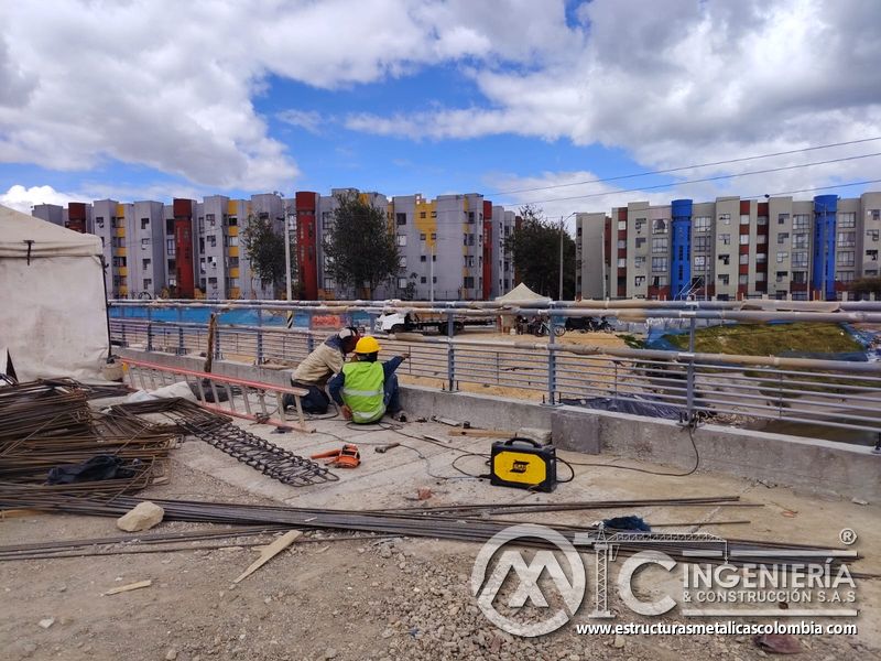 Observe la soldadura que cierra juntas inferiores del cerramiento metálico durante la intervención vial en Bogotá, Colombia. Montajes, Ingeniería y Construcción. MIC SAS.
