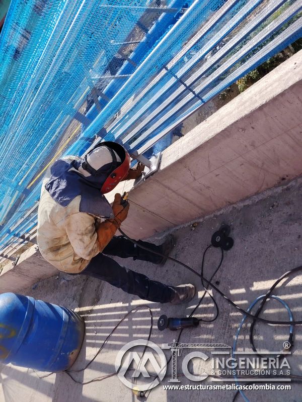 Observe la soldadura cenital que fija el pedestal metálico al murete bajo revisión profesional en campo en Bogotá, Colombia. Montajes, Ingeniería y Construcción. MIC SAS.