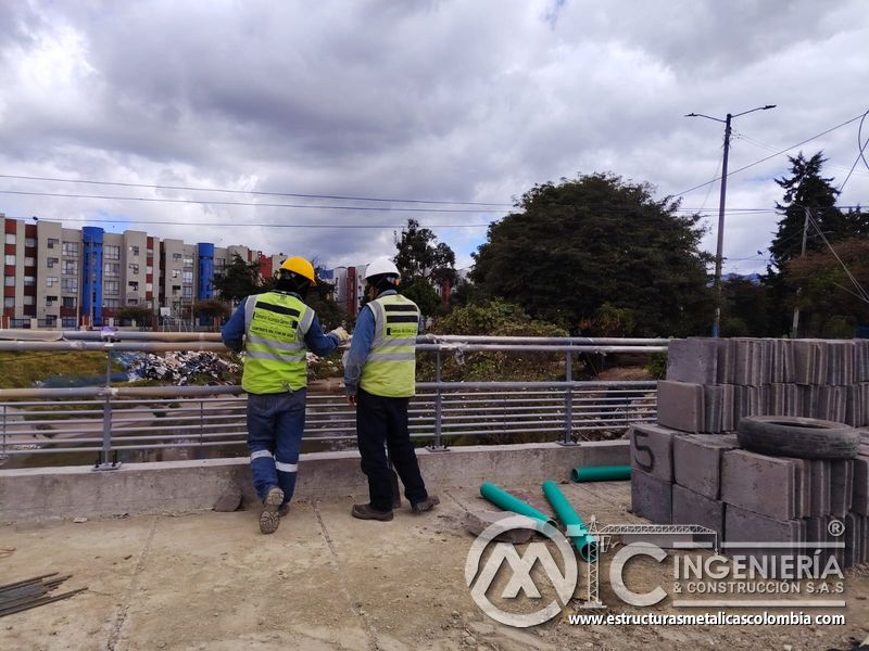 Observe la revisión conjunta del cerramiento terminado junto al canal bajo revisión profesional en obra en Bogotá, Colombia. Montajes, Ingeniería y Construcción. MIC SAS.