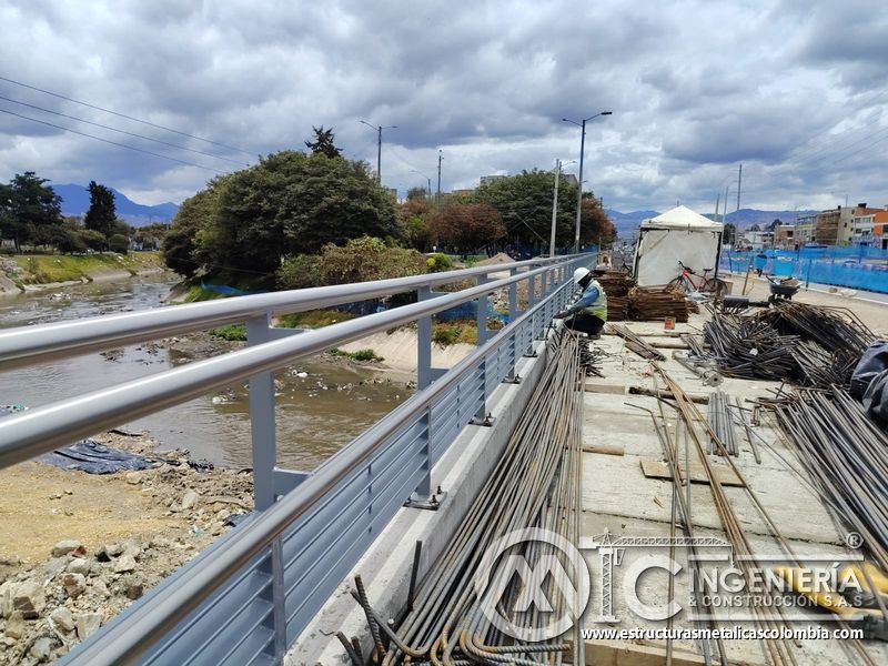 Contemple la baranda terminada entre el río y el acero almacenado con supervisión experta en el montaje en Bogotá, Colombia. Montajes, Ingeniería y Construcción. MIC SAS.