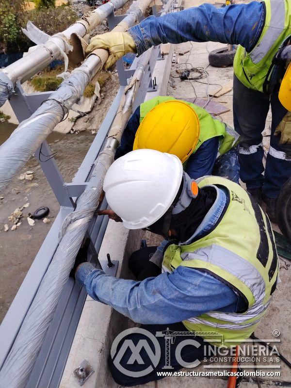Observe la coordinación de tres técnicos sobre los anclajes del murete bajo supervisión técnica en obra en Bogotá, Colombia. Montajes, Ingeniería y Construcción. MIC SAS.