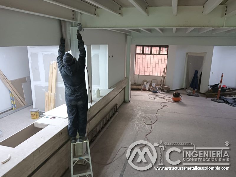 Acabado de viga y columna mediante escalera bajo el mezzanine metálico en Bogotá y Colombia. Montajes Ingeniería y Construcción. MIC SAS.