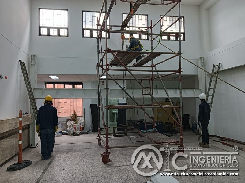 Andamio central y cuadrilla preparan vigas del mezzanine metálico en Bogotá y Colombia. Montajes Ingeniería y Construcción. MIC SAS.