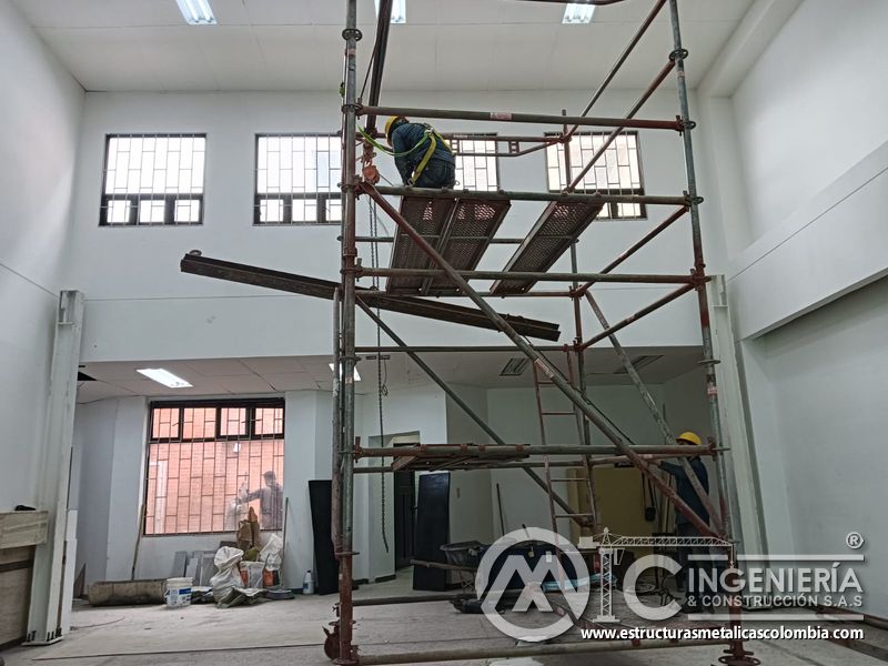 Andamio con polipasto sostiene perfil durante montaje de mezzanine metálico en Bogotá y Colombia. Montajes Ingeniería y Construcción. MIC SAS.