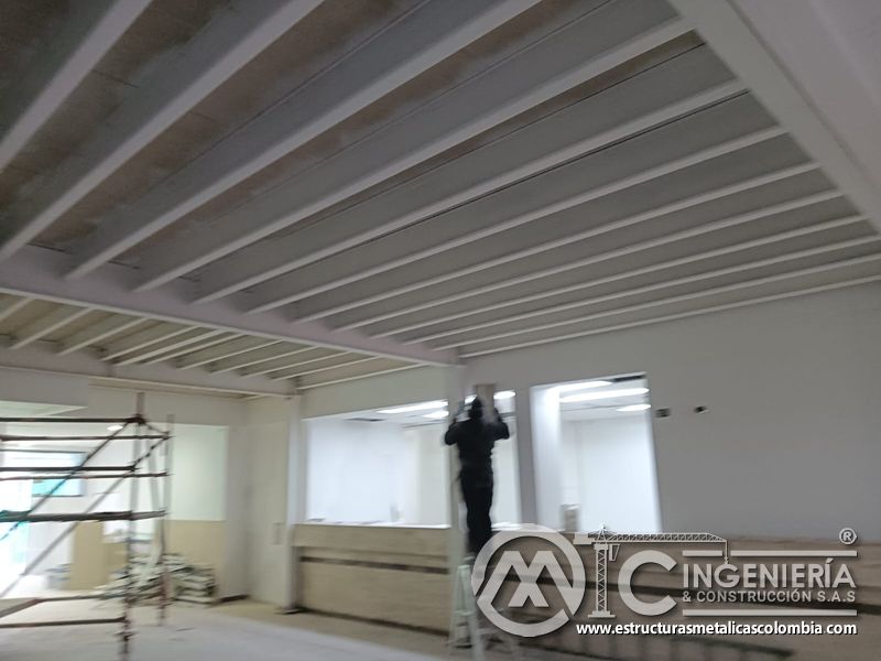 Aplicacion de acabado blanco en columna de soporte del mezzanine metálico en Bogotá y Colombia. Montajes Ingeniería y Construcción. MIC SAS.