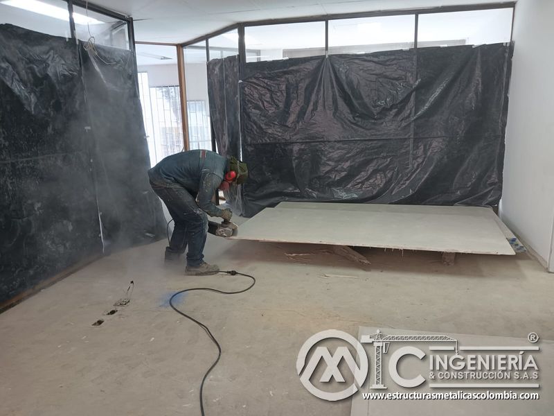 Corte controlado de una placa junto a barrera protectora del mezzanine metálico en Bogotá y Colombia. Montajes Ingeniería y Construcción. MIC SAS.