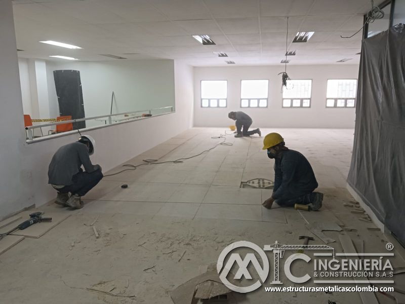 Cuadrilla instala paneles de piso sobre viguetas del mezzanine metálico en Bogotá y Colombia. Montajes Ingeniería y Construcción. MIC SAS.