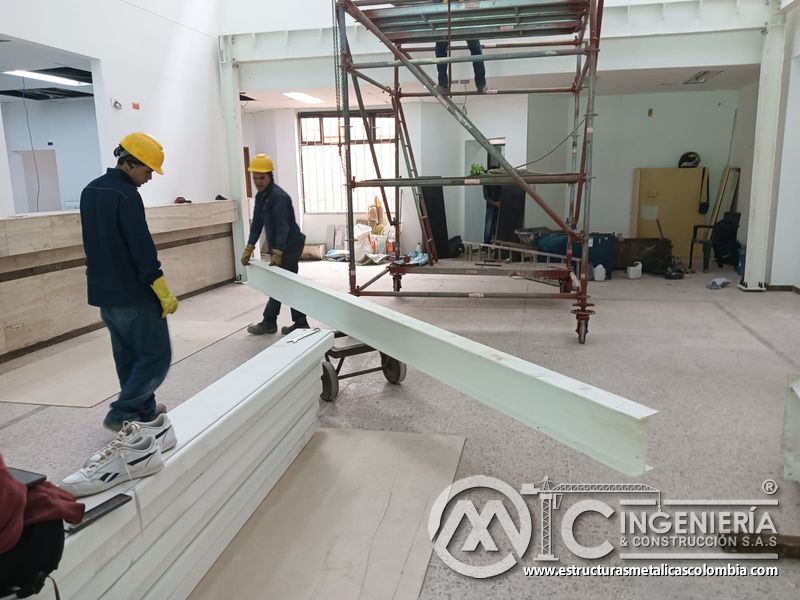 Cuadrilla transporta perfil blanco para montaje del mezzanine metálico en Bogotá y Colombia. Montajes Ingeniería y Construcción. MIC SAS.