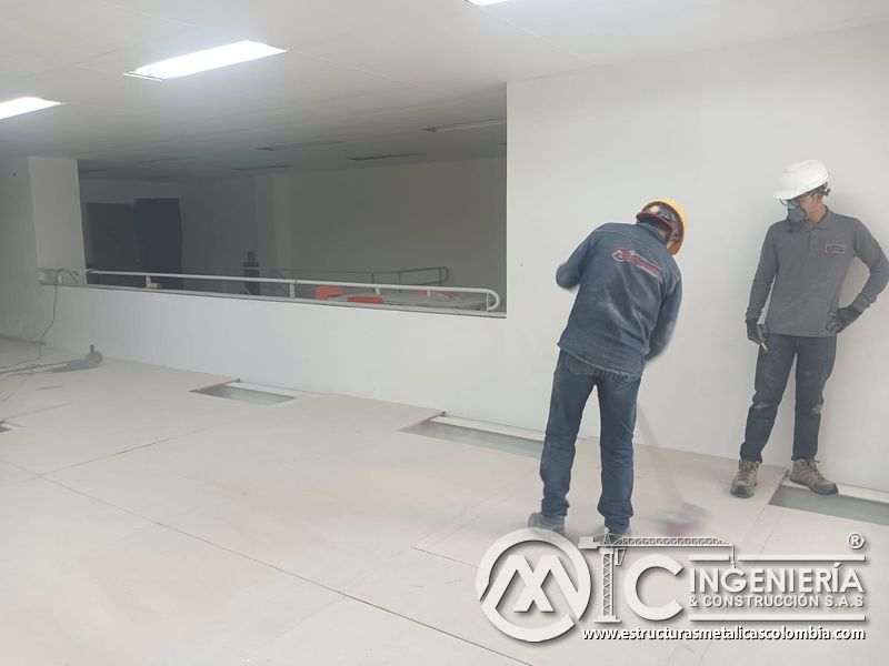 Operarios inspeccionan la plataforma superior del mezzanine metálico en Bogotá y Colombia. Montajes Ingeniería y Construcción. MIC SAS.