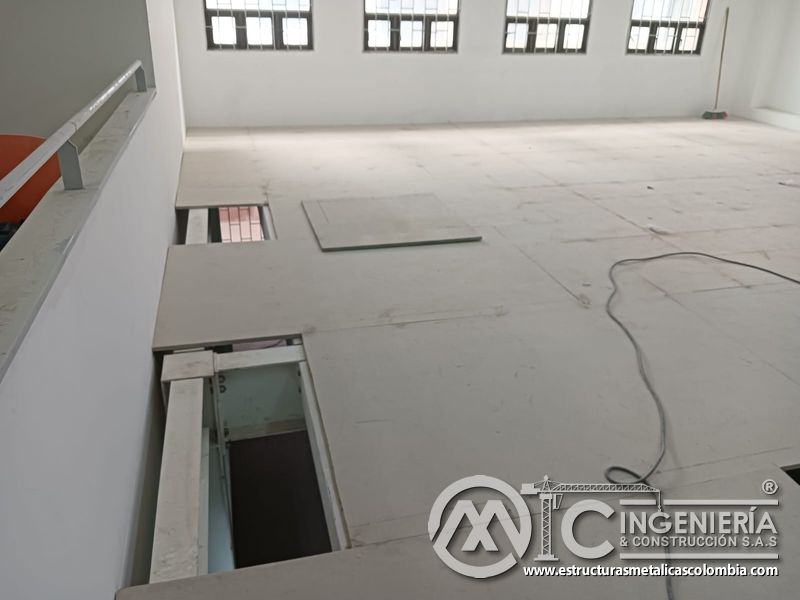 Piso del mezzanine metálico con aberturas de inspección y placas alineadas en Bogotá y Colombia. Montajes Ingeniería y Construcción. MIC SAS.