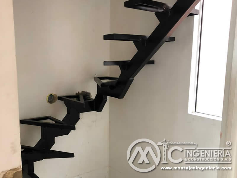 Diseño y montaje de escaleras con peldaños en metal y superficie en madera en Bogotá, Colombia. Montajes, Ingeniería y Construcción. MIC SAS