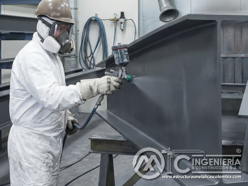 Pulverización de pintura industrial sobre vigas metálicas preparadas en Bogotá, Colombia. Montajes, Ingeniería y Construcción. MIC SAS.