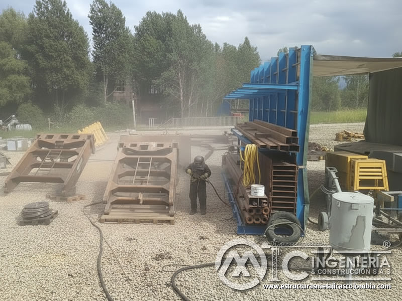 Sandblasting de piezas metálicas industriales en campo abierto en Bogotá, Colombia. Montajes, Ingeniería y Construcción. MIC SAS.