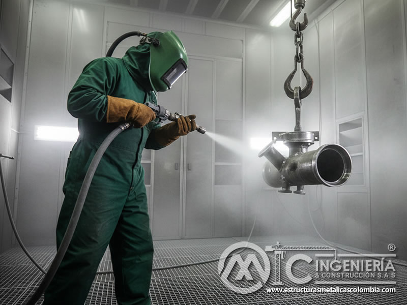 Chorreado abrasivo de válvula metálica colgada con cadena en cabina en Bogotá, Colombia. Montajes, Ingeniería y Construcción. MIC SAS.