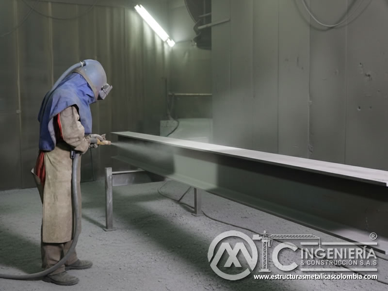 Limpieza de viga de acero con chorro de arena en cabina industrial en Bogotá, Colombia. Montajes, Ingeniería y Construcción. MIC SAS.