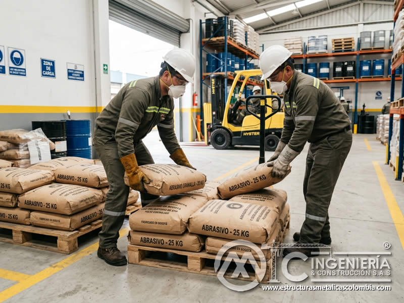 Carga y descarga segura de abrasivos con uso de guantes, respirador y protección personal en Bogotá, Colombia. Montajes, Ingeniería y Construcción. MIC SAS.