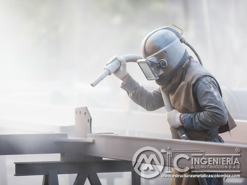 Sandblasting sobre perfil metálico con casco de protección completa. Bogotá, Colombia. Montajes, Ingeniería y Construcción. MIC SAS.