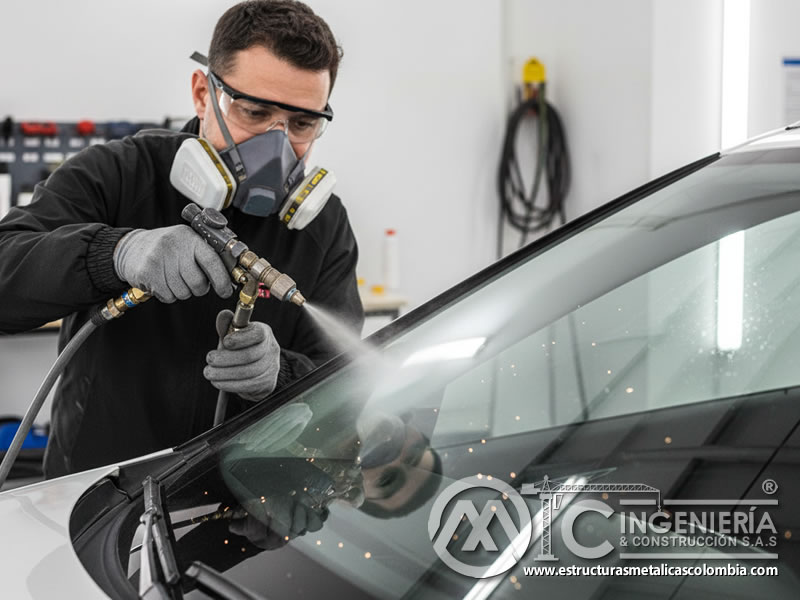 Parabrisas automotriz siendo preparado con carburo de silicio para recubrimiento. Bogotá, Colombia. Montajes, Ingeniería y Construcción. MIC SAS.