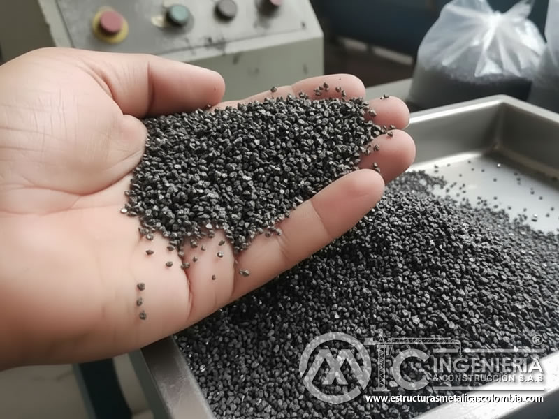 Escoria de cobre negra grisácea de granulometría fina sostenida en mano en planta industrial. Bogotá, Colombia. Montajes, Ingeniería y Construcción. MIC SAS. Escoria de cobre negra grisácea de granulometría fina sostenida en mano en planta industrial. Bogotá, Colombia. Montajes, Ingeniería y Construcción. MIC SAS.