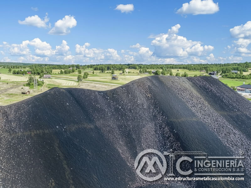 Vista aérea de gran depósito de escoria de cobre negra con paisaje verde al fondo. Bogotá, Colombia. Montajes, Ingeniería y Construcción. MIC SAS. Vista aérea de gran depósito de escoria de cobre negra con paisaje verde al fondo. Bogotá, Colombia. Montajes, Ingeniería y Construcción. MIC SAS.