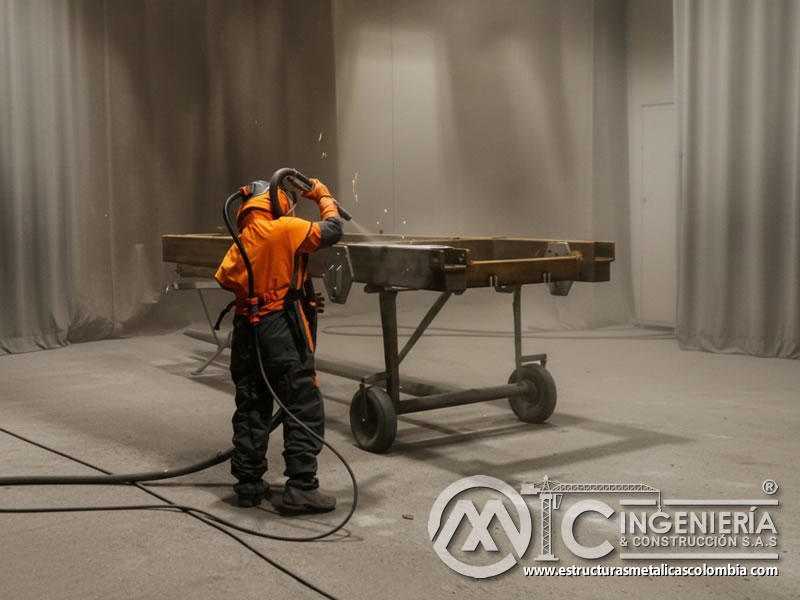 Sandblasting con granate en estructura soldada sobre carrito en cabina de granallado. Bogotá, Colombia. Montajes, Ingeniería y Construcción. MIC SAS.